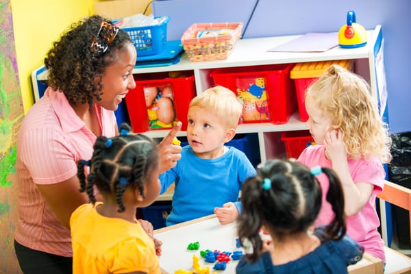 Early years practitioner talking with a group of toddlers
