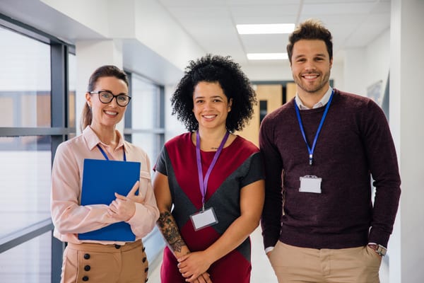 Three school staff standing together in a corridor